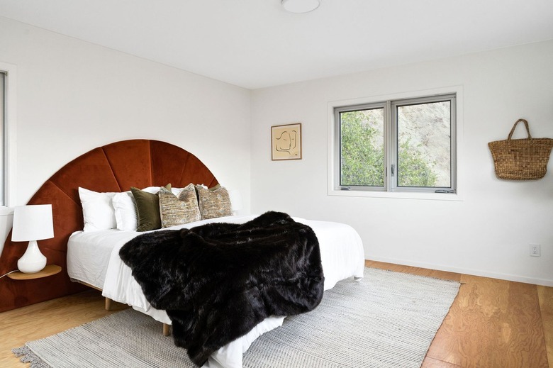 primary bedroom with white bed and red velvet headboard