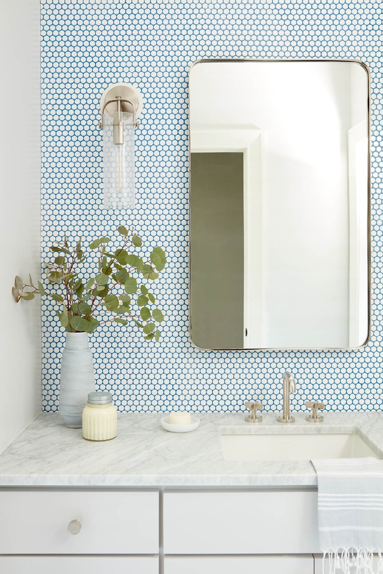 modern traditional blue and white bathroom with white penny tile backsplash with blue grout