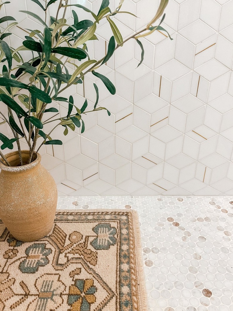 close-up detail of organic modern bathroom with marble penny tile in whites and neutrals and coordinating hex wall tile