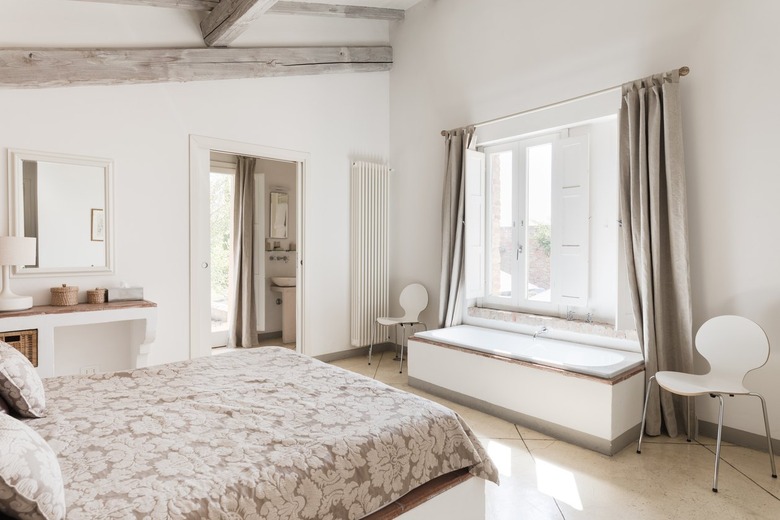 White bedroom with window bench and long curtains