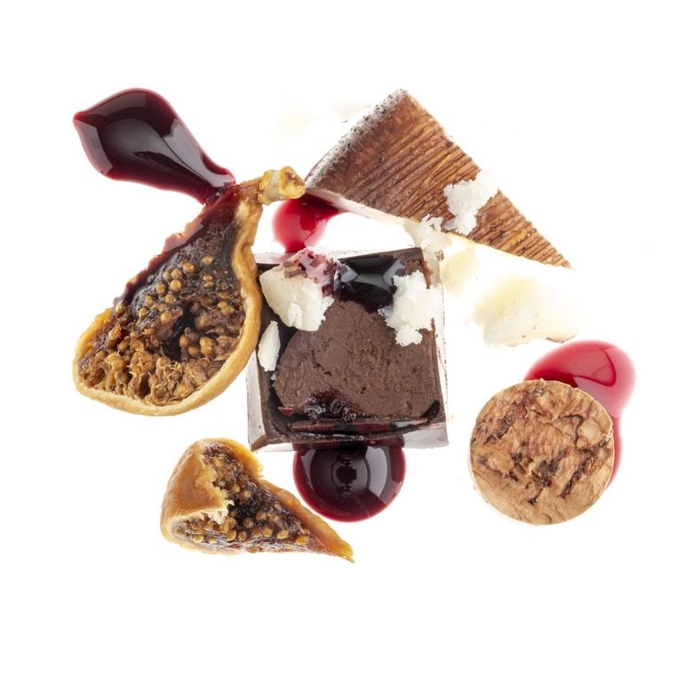 A piece of medium-dark chocolate surrounded by an open fig