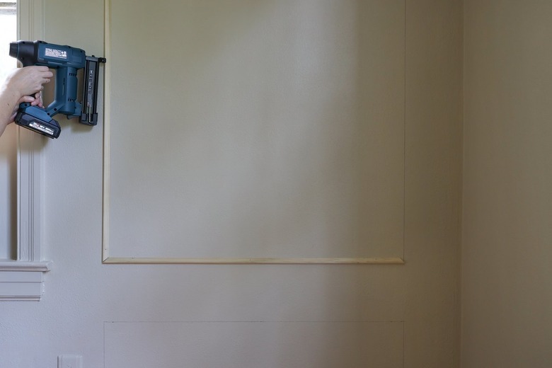 Brad nailing molding piece to the wall