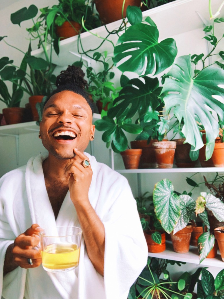 person in white robe near plants