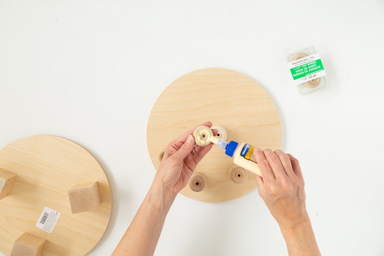 Add glue to wood circle for DIY plant riser