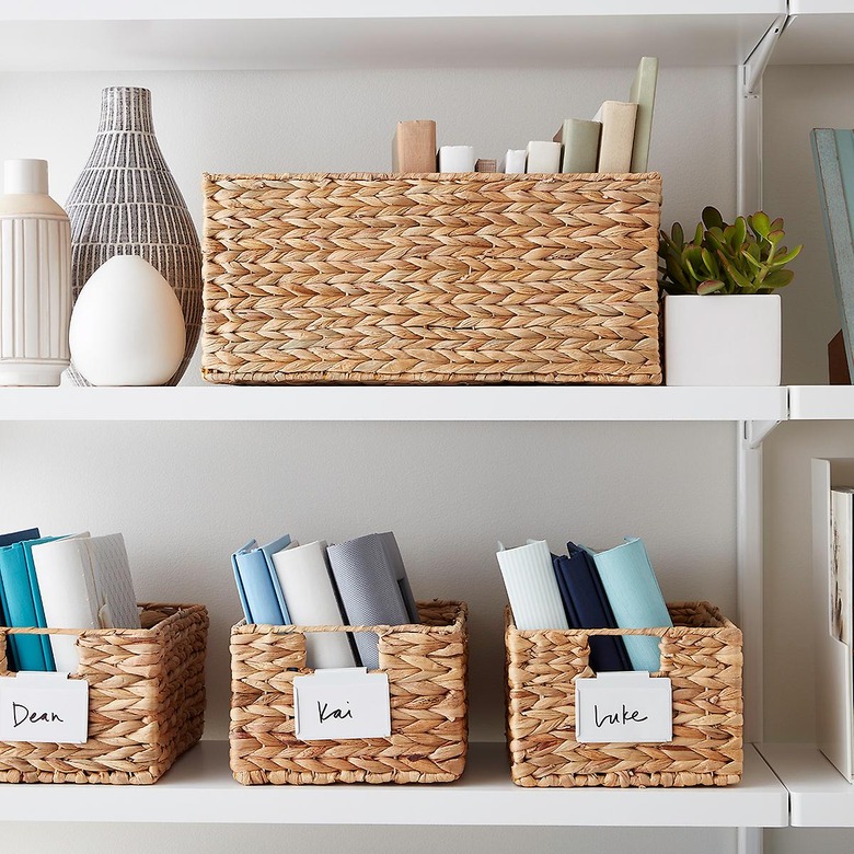 Water hyacinth storage containers on white shelves with books