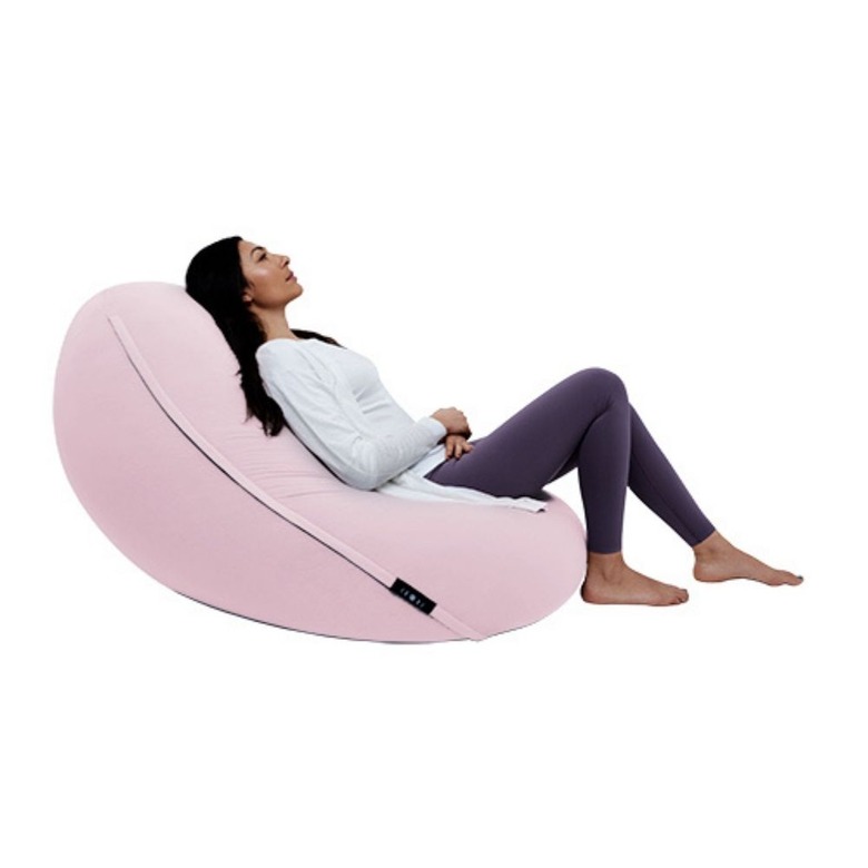 woman laying on pink bean bag chair