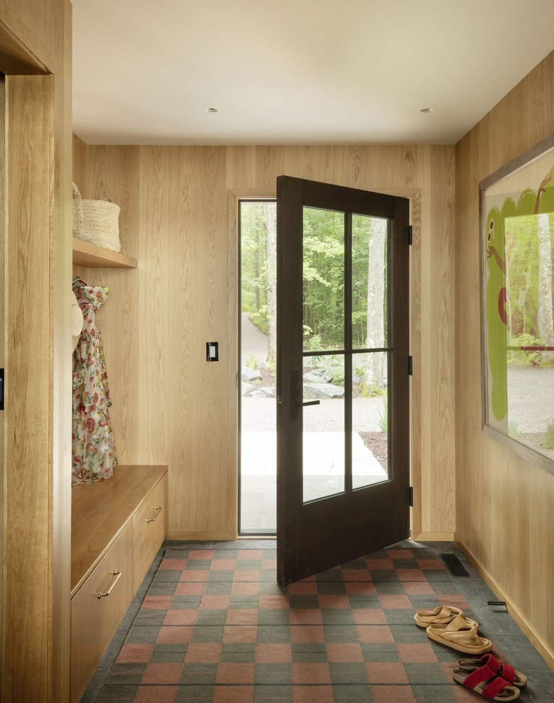 entry with wood walls and checkerboard floor and a slightly open door