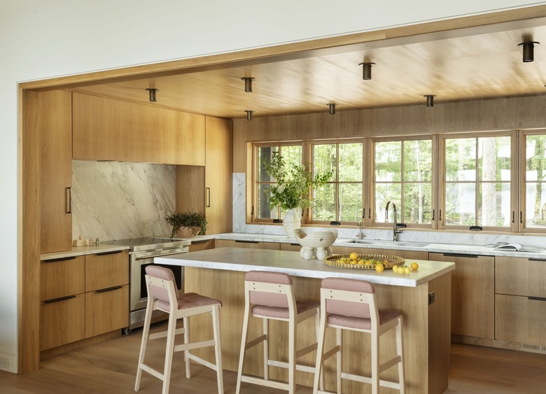 kitchen area with white oak cabinets and island with counter stools