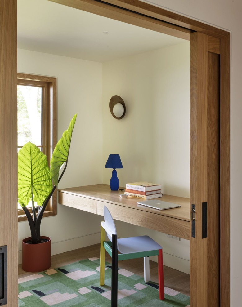colorful home office featuring a multicolored chair and a large potted plant