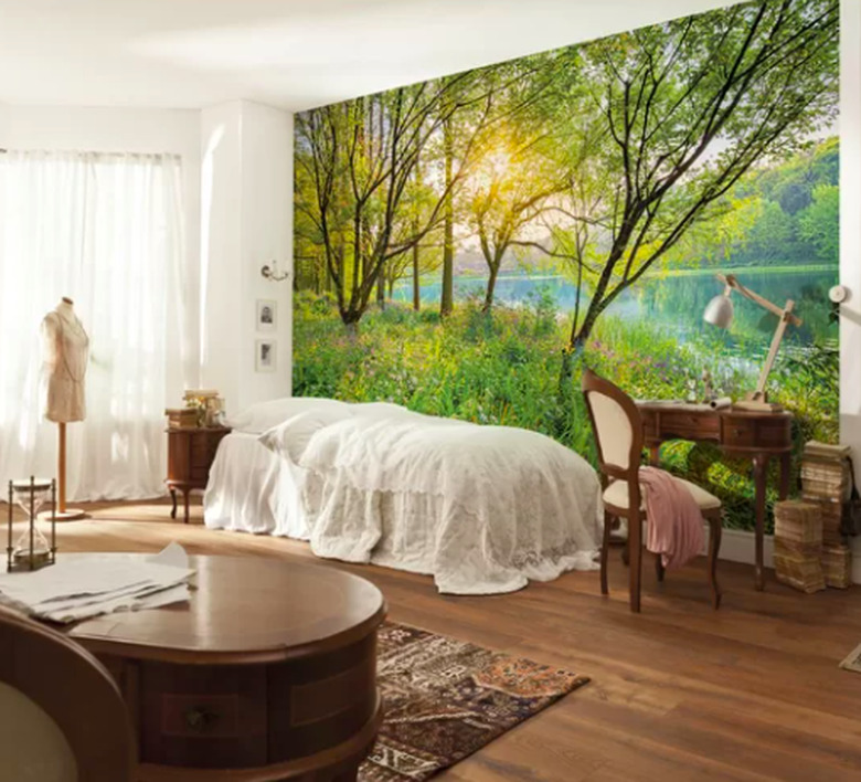 Bedroom with trees and water wallpaper with withe bed and desk