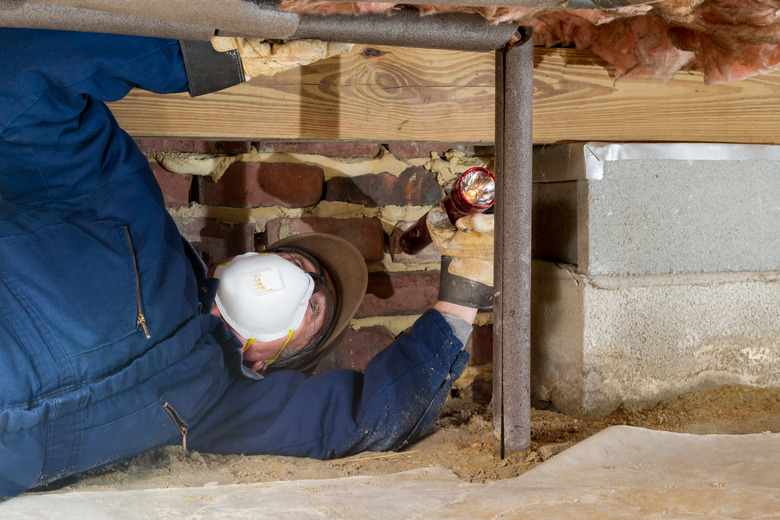 Home inspector examines a freeze protected crawl space water line.