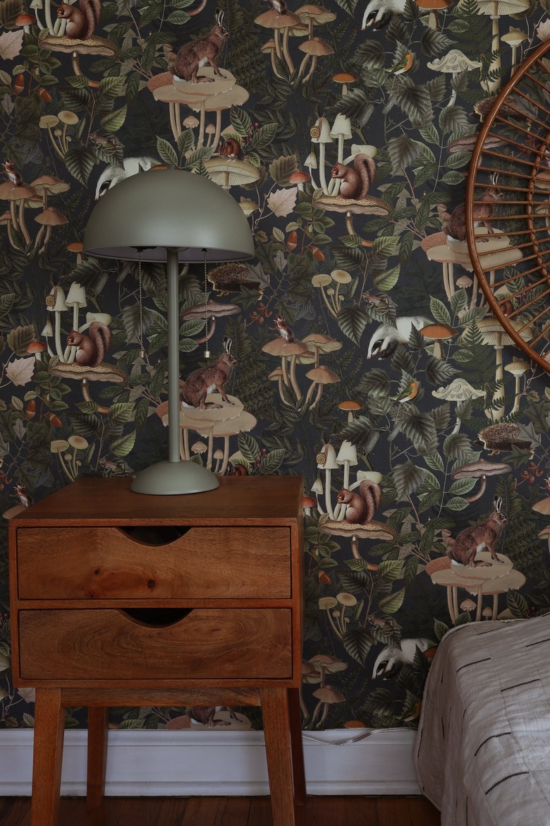 Green forest animal wallpaper attached to wall with painter's tape