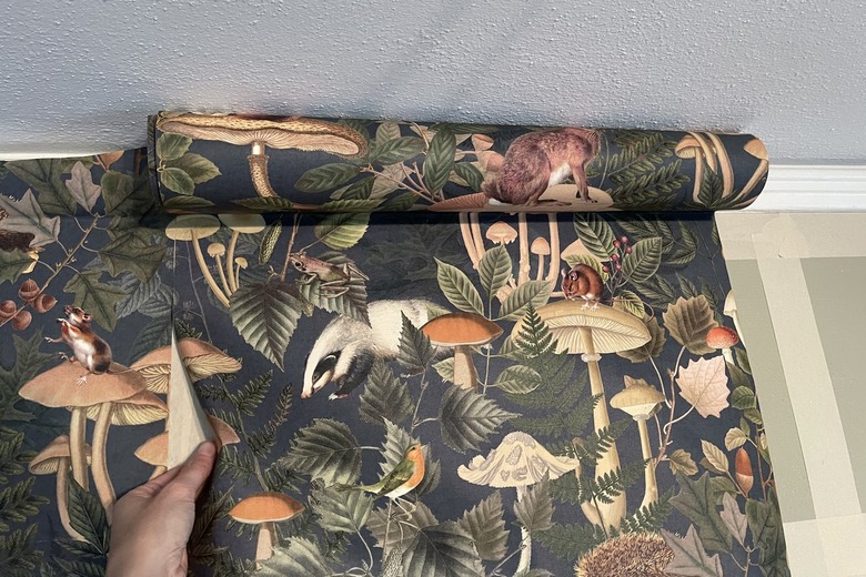 Lining up green forest animal wallpaper pattern on the wall