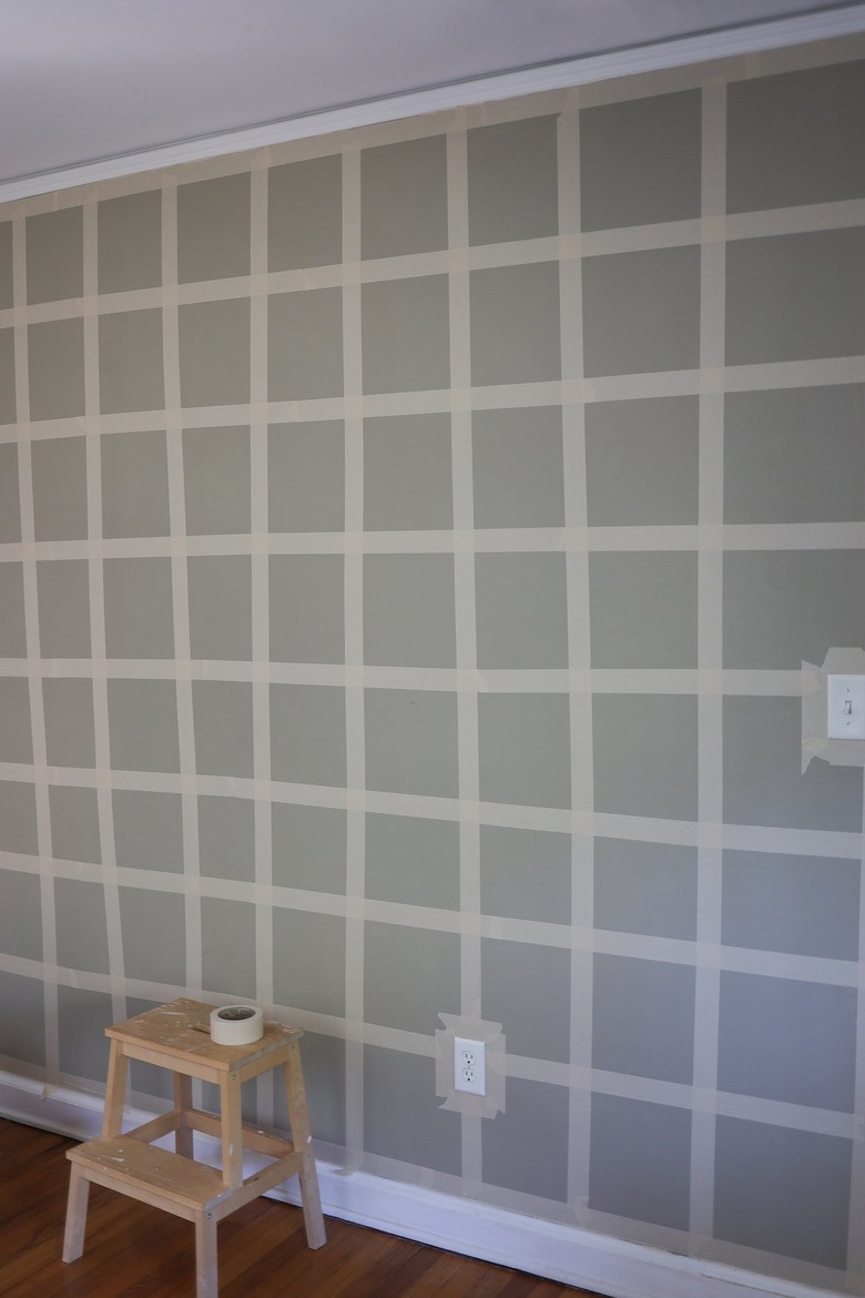White painter's tape grid on green painted wall