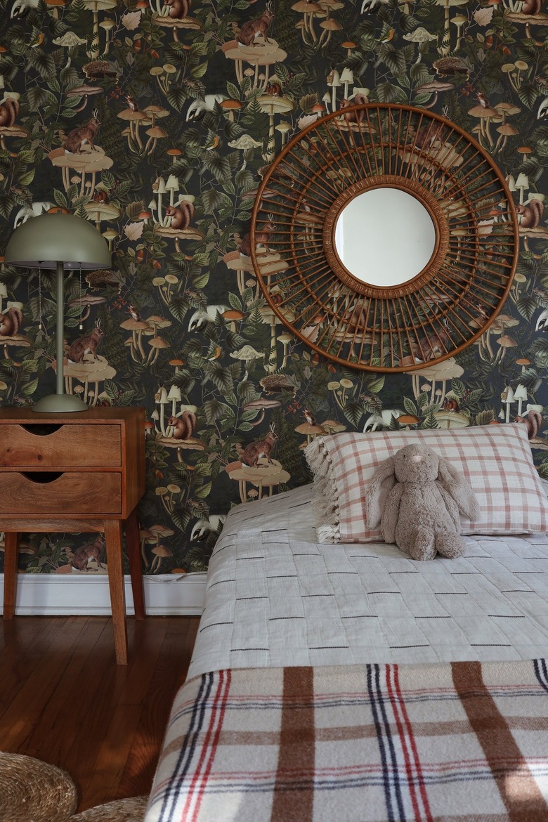 Removable green forest animal wallpaper in kids room with plaid bedding