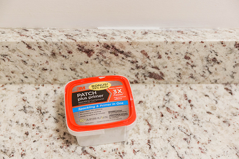 Fill areas of missing drywall with spackling compound.