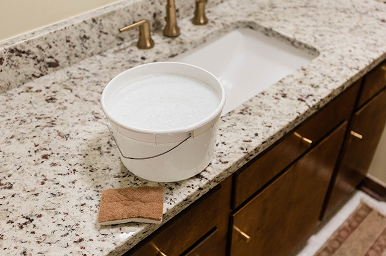 Wash down the cabinet doors and surround using soapy water and a sponge.
