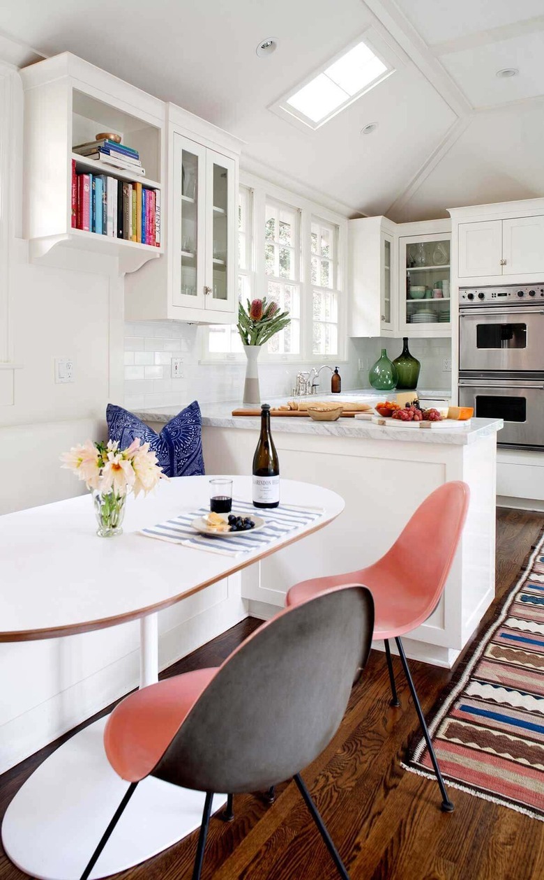 white kitchen with pink blue and brown woven rug