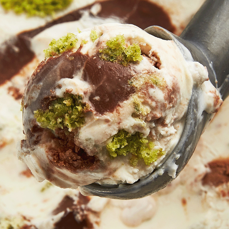 Salt and Straw's Spinach Cake with Chocolate Tahini Fudge. The ice cream is white and filled with chocolate frosting and bits of green cake.