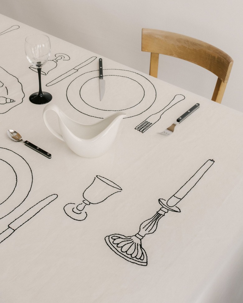 A white tablecloth embroidered with a candlestick