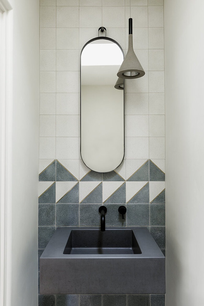 small powder room with gray sink and concrete light