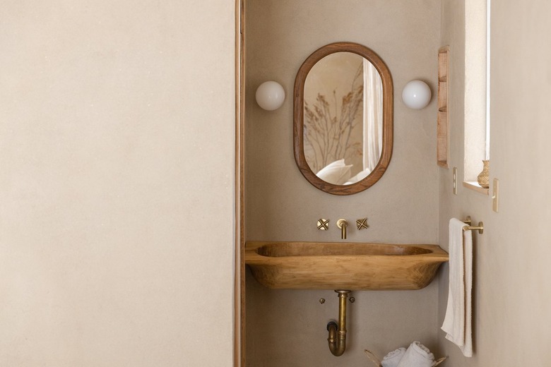 Minimalist bathroom with a wood oval mirror