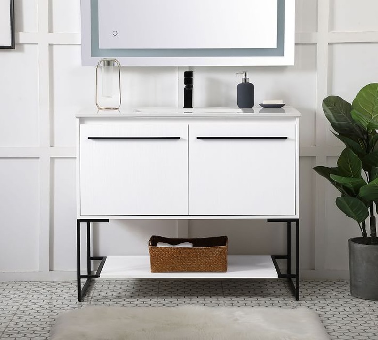 White Scandinavian bathroom vanity with black handles in white bathroom