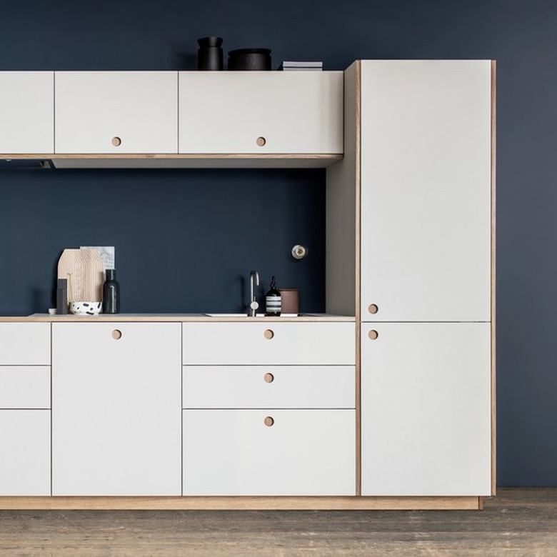 kitchen space with white cabinets and dark blue wall
