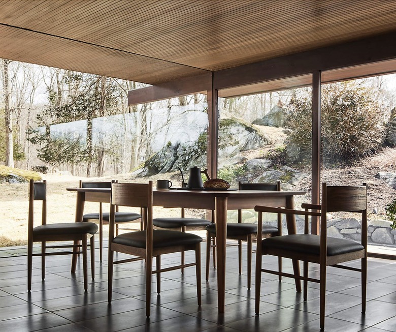 Image of a large Scandinavian-style table in a sunroom surrounded by chairs