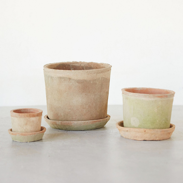 three clay planters with saucers