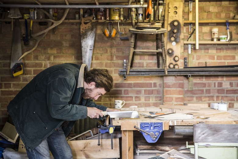 Man working standing at a workbench in a woodworking workshop