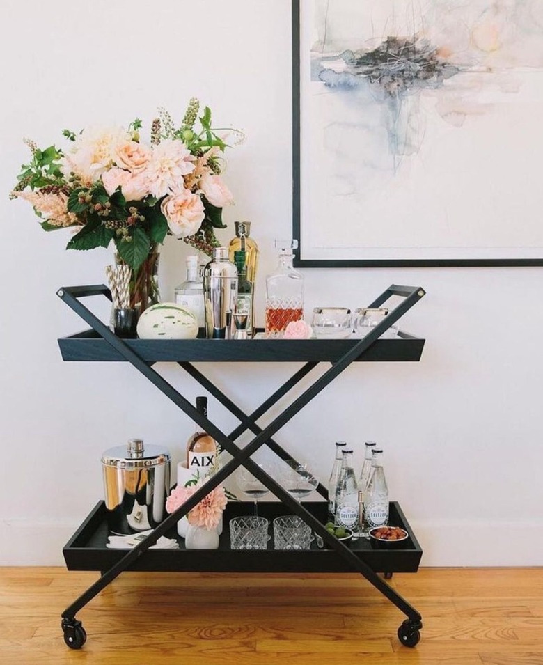 Black metal bar cart with floral arrangement