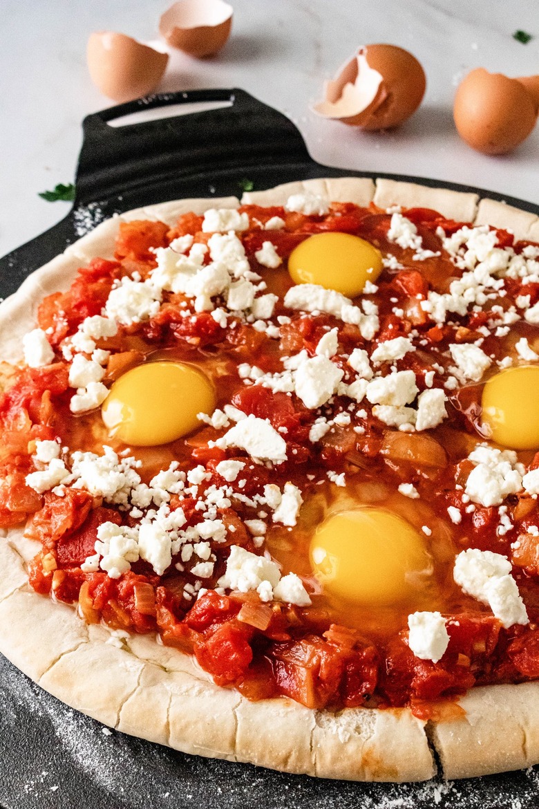 Shakshuka pizza with raw eggs before baking