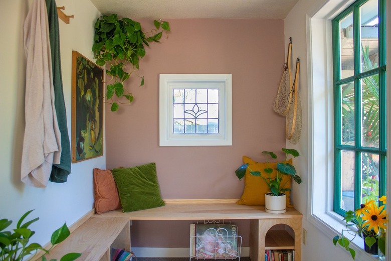 A sun room with a built-in bench and walls painted red-beige