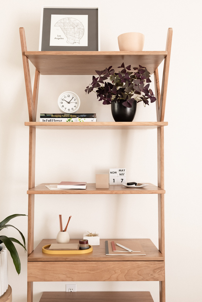 wooden shelving unit in bedroom styled with decorative accents