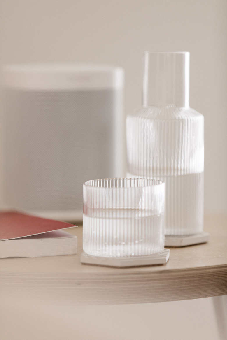 birch side table with glass carafe and speaker close up