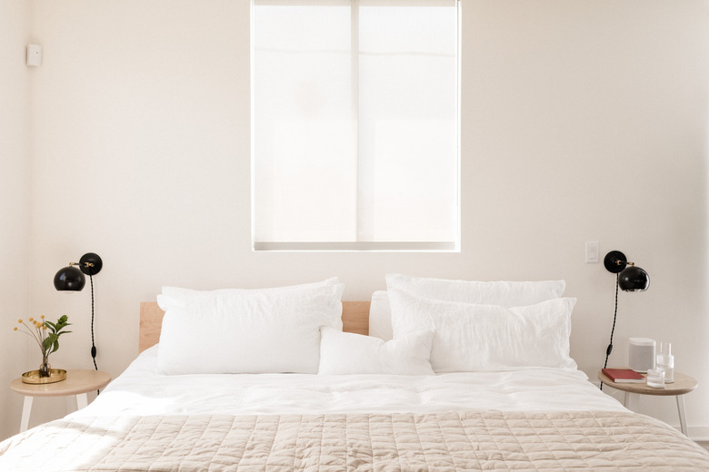 platform bed with white and beige linens and matching side tables