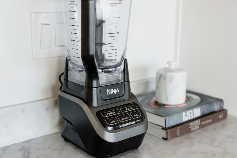 Black Ninja blender on a marble countertop. Next to the blender