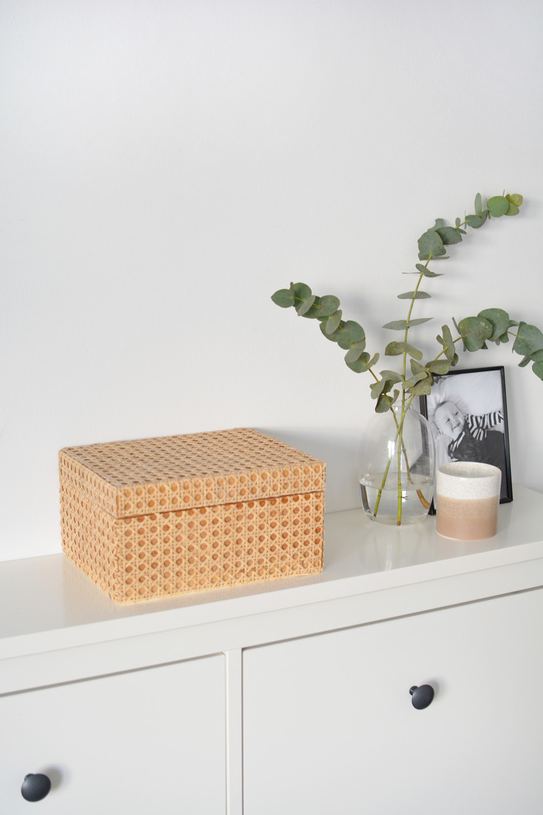 Wooden box covered in cabe on white unit with candle