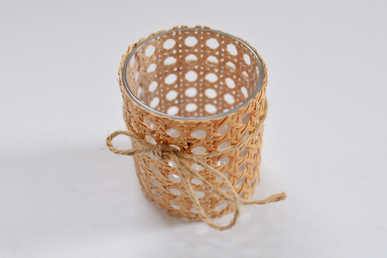 cane wrapped around glass with jute string tied around.