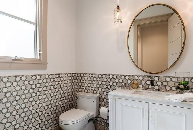 small modern bathroom with large circular mirror