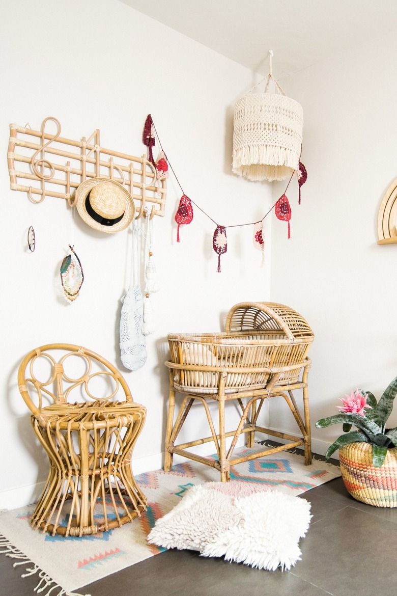 Nursery with boho rattan chair and crib. Rattan music note hanger. Crochet pendant light