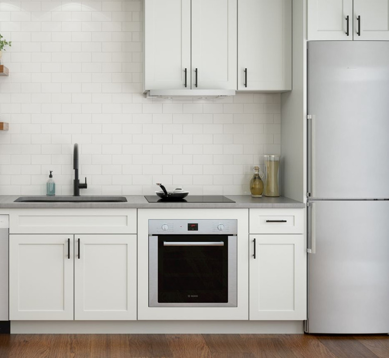 Induction cooktop with wall oven in white kitchen. Small Stove and Oven