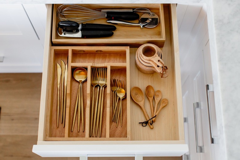 An open cutlery drawer with a wooden organizer