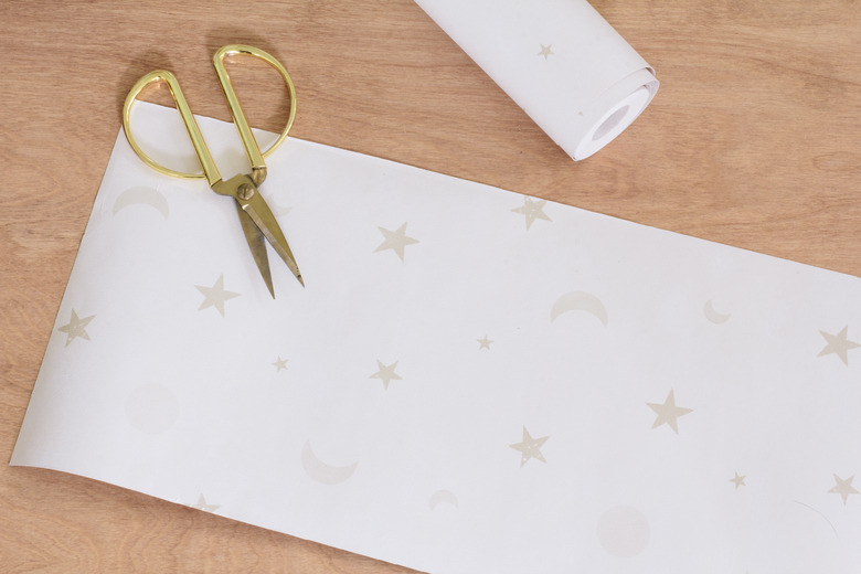 Cutting strips of wallpaper