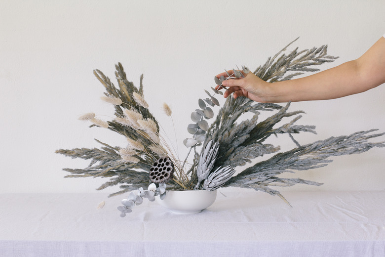 Placing eucalyptus into vase