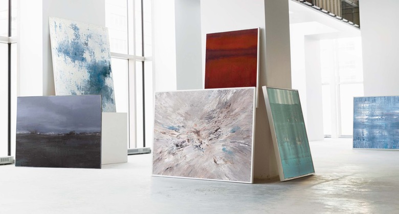 White gallery space with large abstract paintings leaned against walls