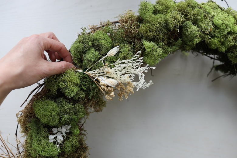 Attaching dried floral bundle to wreath with wire