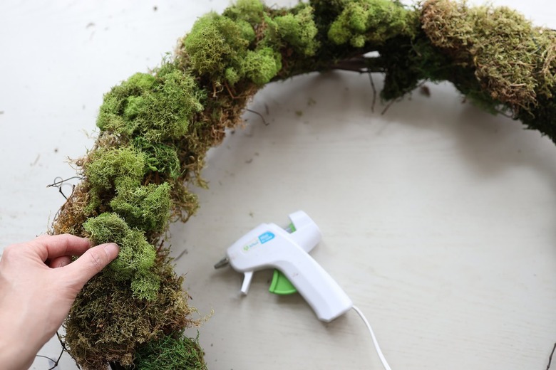 Gluing reindeer moss to wreath