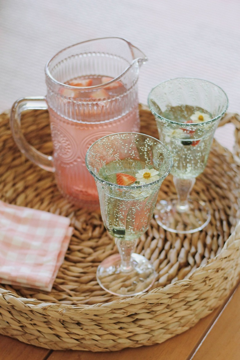 Pink lemonade served inside green plastic goblet glasses for patio